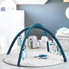 a baby play gym with toys on the floor in a child's nursery room