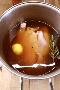 a metal bowl filled with soup on top of a wooden table