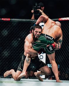 two men are wrestling in a caged area