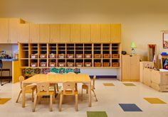 a classroom with tables, chairs and shelves full of books on the wall behind them