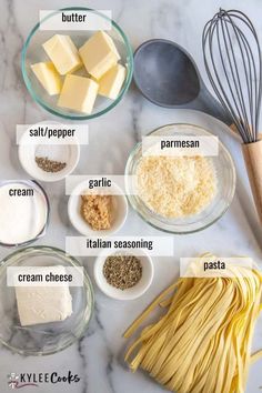 the ingredients to make pasta laid out on a marble counter top, including butter, garlic, parmesan cheese and seasoning