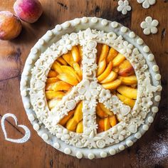 a pie with white frosting and sliced peaches in the shape of a peace sign