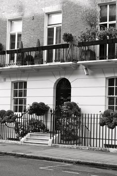 a black and white photo of an apartment building with balconies on the balcony