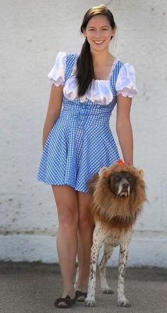 a woman in a blue and white dress holding a dog