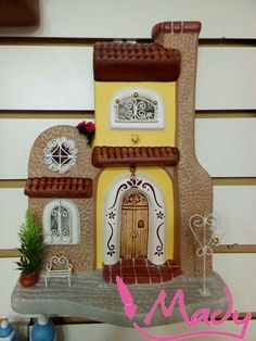 a doll house made out of clay with a door and windows on the outside wall