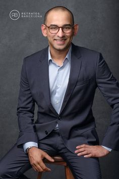 a man in a suit sitting on a stool