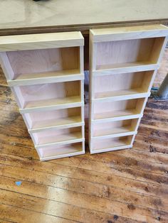 two unfinished bookshelves sitting on top of a wooden floor