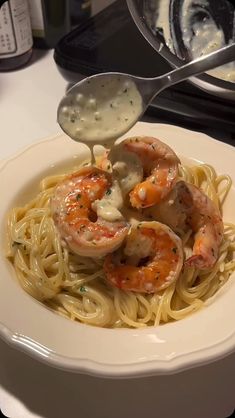 a spoon scooping some shrimp over pasta