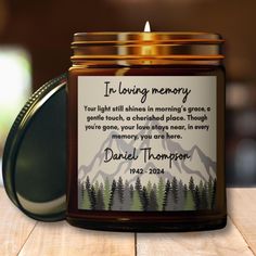 a candle that is on top of a wooden table next to a jar with a poem in it