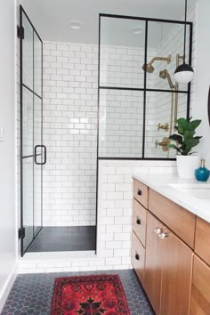 a bathroom with a rug, sink and shower stall in it's center area