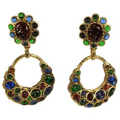 Rare and exceptional Chanel Poured Glass Hoop Earrings from the 1990's. Completely hand made in the studios of Maison Gripoix in Paris. This poured glass process is no longer used by Chanel except for buttons, on occasion for Haute Couture jackets and coats in excess of 30,000 dollars. Exceptional colorations in ruby, sapphire and emerald pate de verre glass set in hammered bronze. Motif and stones are duplicated on back, showing the quality of manufacture. Clip back fittings. 1990's France. Top Vintage Chanel Earrings, Vintage Drop Earrings, Couture Jackets, Gold Chanel, Chanel Earrings, Ruby Sapphire, Earrings Drop, Vintage Chanel, Vintage Costume Jewelry