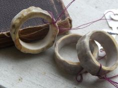 two wooden rings sitting on top of a table next to an open book and string