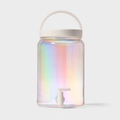 a glass jar with a white lid and rainbow holographics on the side