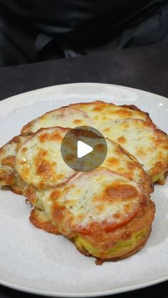 two cheese pizzas on a white plate with a black table in the back ground