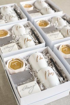 six boxed candles in white boxes with gold lettering