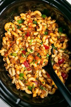 a crock pot filled with macaroni, cheese and meat in a chili sauce