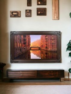 a painting hanging on the wall above a tv