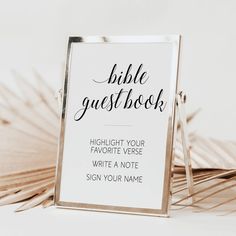 a bible guest book sign sitting on top of a pile of palm fronds