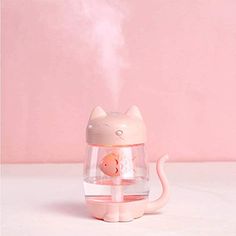 a pink cat humider sitting on top of a white table next to a pink wall