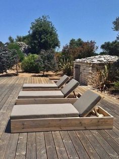 four lounge chairs sitting on top of a wooden deck