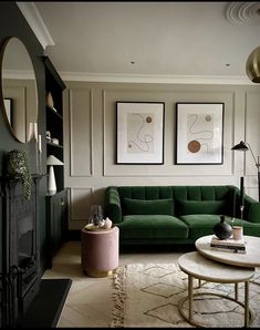 a living room with green couches and pictures on the wall