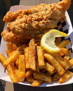 fried chicken and french fries with lemon wedges