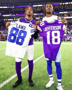 two football players holding jerseys on the field