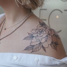 a woman with a flower tattoo on her chest