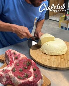 a man cutting meat on top of a wooden cutting board