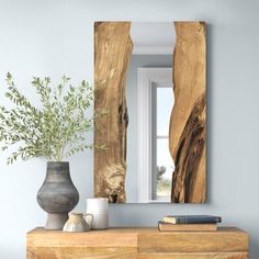 a wooden dresser with a vase and mirror on it