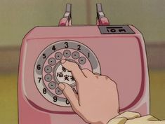 a person pressing buttons on an old pink phone