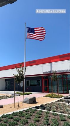 an american flag is flying in front of a building with a red and white roof