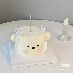 a cake shaped like a teddy bear with a candle in the shape of a head