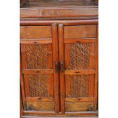 an old wooden cabinet with rattan doors and drawers on the bottom, side view