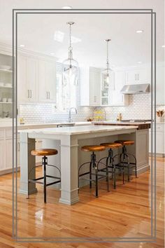 a large kitchen with white cabinets and wooden floors is pictured in this image, there are stools at the center of the island