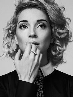 a black and white photo of a woman wearing a neck tie with her hands to her mouth