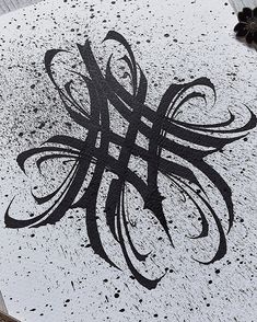 a black and white drawing of a letter h on the ground with ink splatters