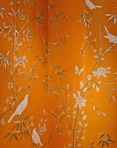 an orange wall with birds and flowers on it