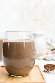 a glass filled with chocolate pudding sitting on top of a wooden cutting board next to other ingredients