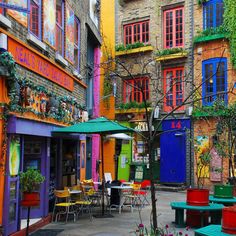 an alleyway with many colorful buildings and tables