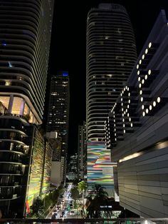 a city street at night with tall buildings