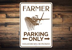 a sign that is on the side of a wooden wall saying, farmer parking only violators will be plowed