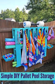 a wooden fence with towels hanging on it and the words simple diy pallet pool storage