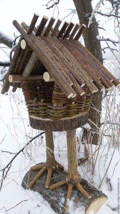 a bird house made out of logs in the snow