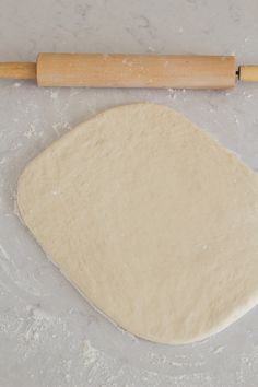 the dough is ready to be rolled into smaller sized pieces with a rolling pin in the background