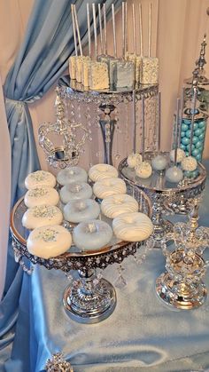 a table topped with lots of cupcakes covered in frosting next to cakes