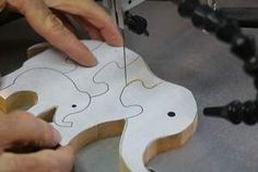 a person is cutting wood with scissors on a piece of paper that has been cut into the shape of an elephant