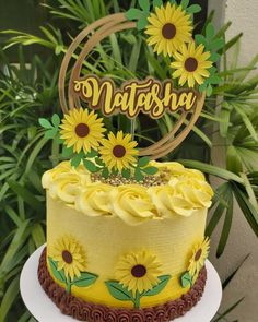 a yellow cake with sunflowers on it and a wooden sign that says nattsday