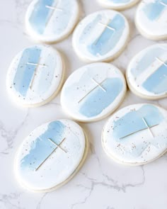 some cookies that have been decorated with blue icing and one has a cross on it