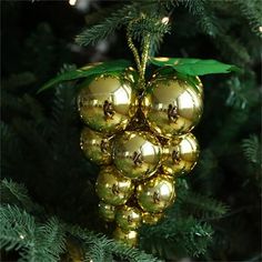 an ornament hanging from a christmas tree with gold baubles on it